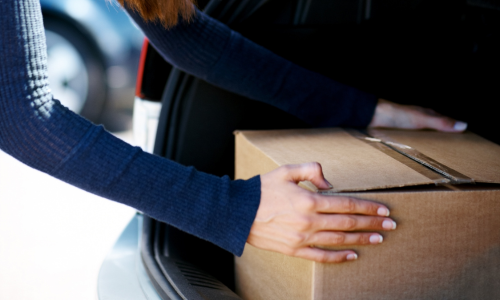 Woman putting. box in her trunk